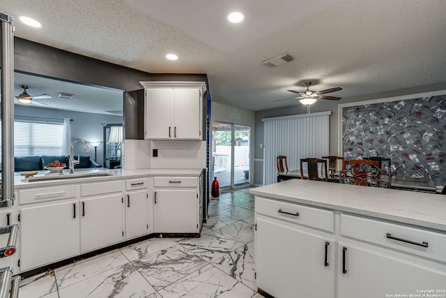 kitchen featuring white cabinetry, a textured ceiling, and plenty of natural light