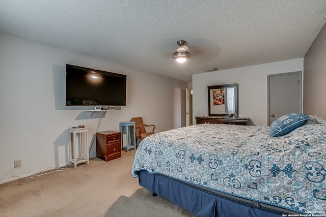 bedroom featuring light carpet, a textured ceiling, and ceiling fan