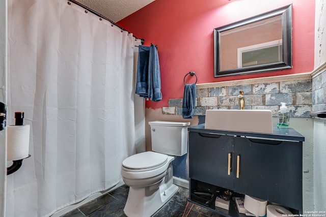 bathroom featuring vanity, toilet, a textured ceiling, and walk in shower