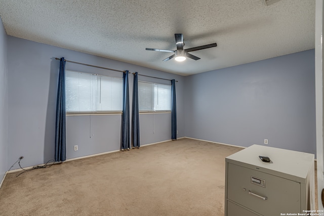 carpeted spare room with ceiling fan and a textured ceiling