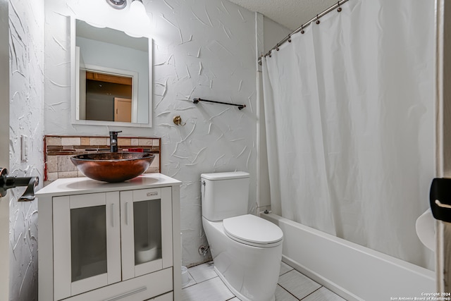 full bathroom with a textured ceiling, toilet, shower / bath combo, vanity, and tile patterned floors