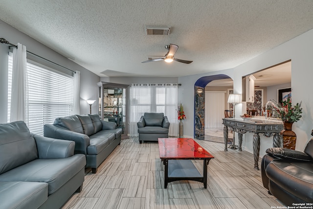 living room featuring a textured ceiling and ceiling fan