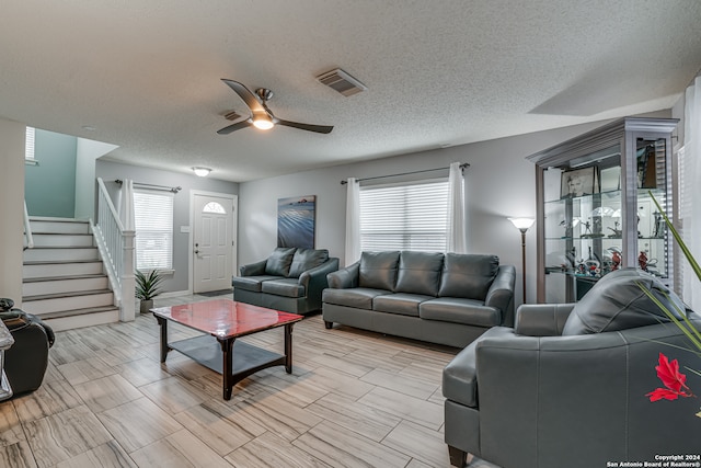 living room with a textured ceiling, a healthy amount of sunlight, and ceiling fan