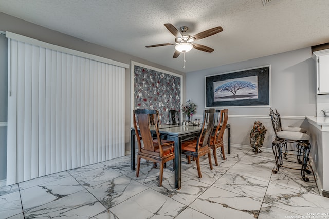 dining space featuring a textured ceiling and ceiling fan