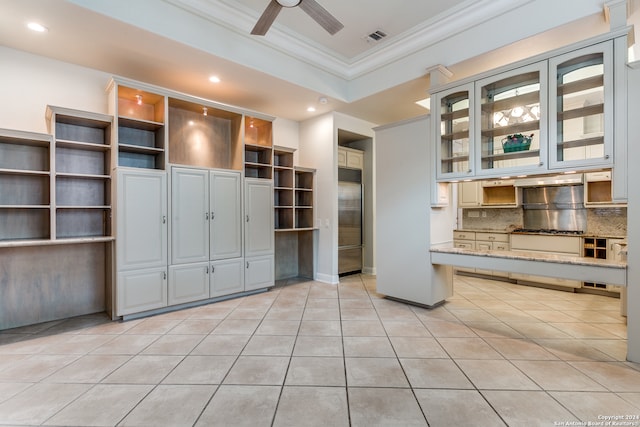 kitchen featuring backsplash, built in refrigerator, light tile patterned floors, ceiling fan, and crown molding