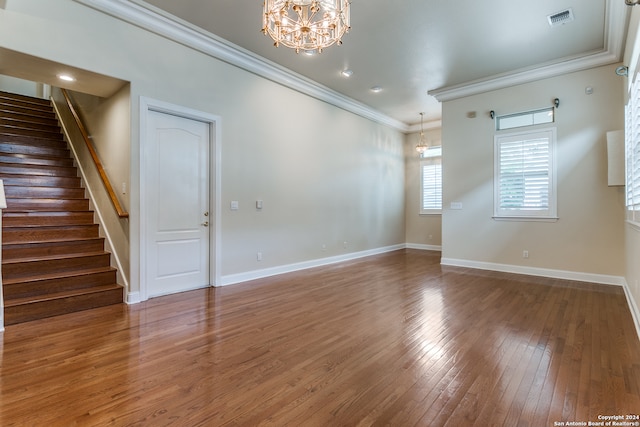 unfurnished room featuring crown molding, hardwood / wood-style floors, and a chandelier