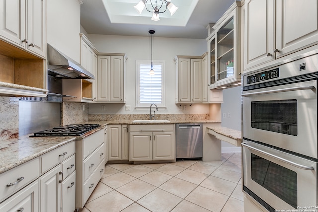 kitchen with wall chimney exhaust hood, sink, decorative light fixtures, light tile patterned floors, and stainless steel appliances