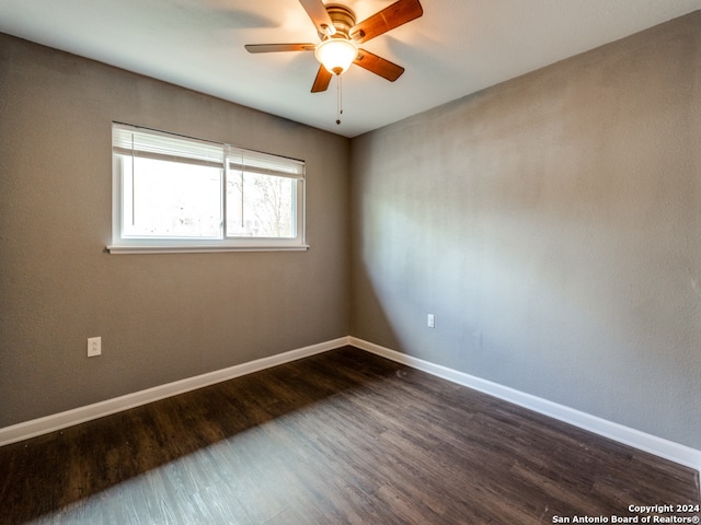 spare room with dark hardwood / wood-style floors and ceiling fan