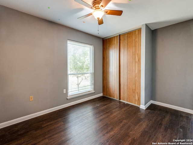 unfurnished bedroom with a closet, ceiling fan, and dark hardwood / wood-style flooring