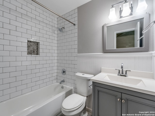 full bathroom featuring tiled shower / bath, vanity, and toilet