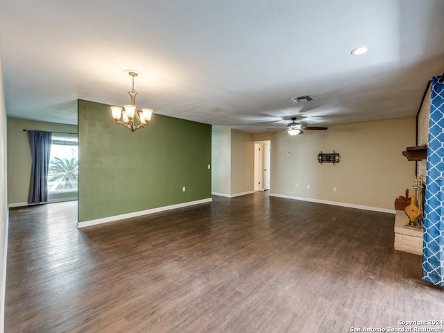 unfurnished living room with dark wood-type flooring and ceiling fan with notable chandelier