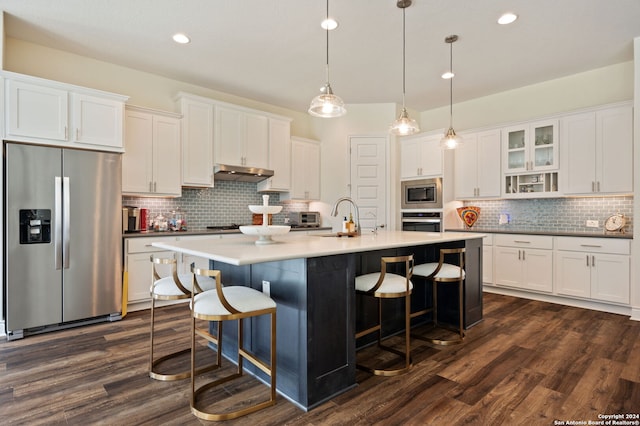 kitchen featuring hanging light fixtures, stainless steel appliances, backsplash, white cabinetry, and dark hardwood / wood-style flooring