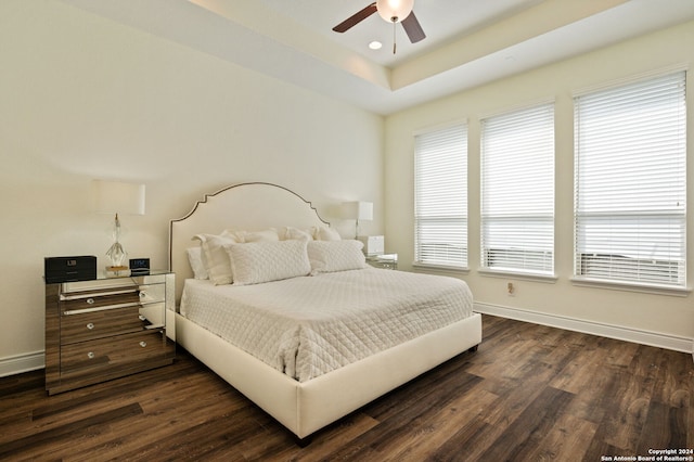 bedroom with ceiling fan, multiple windows, and dark hardwood / wood-style floors