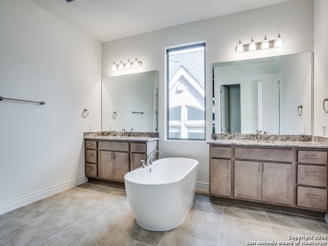 bathroom with vanity, a bathtub, and tile patterned flooring