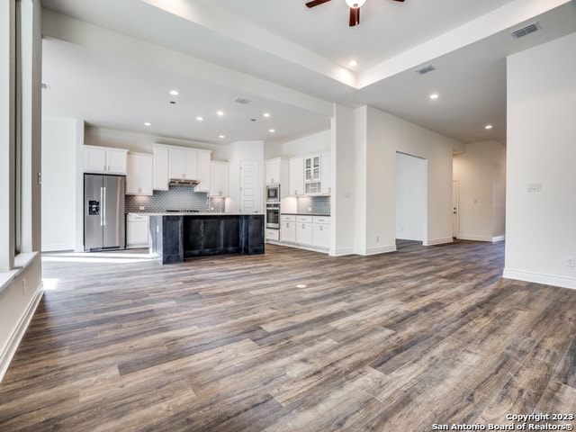 unfurnished living room featuring ceiling fan and dark hardwood / wood-style flooring