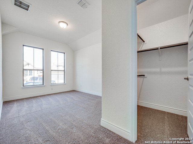 carpeted spare room with lofted ceiling