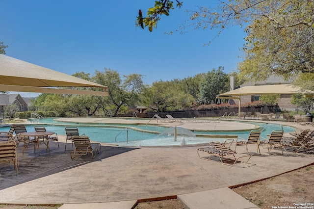 view of swimming pool with pool water feature and a patio area