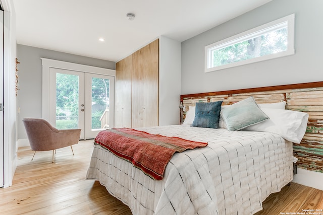 bedroom with french doors, light hardwood / wood-style floors, and access to outside