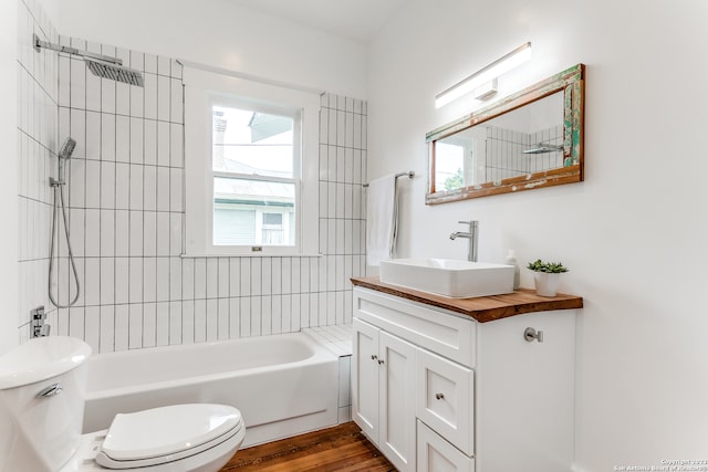 full bathroom with toilet, tiled shower / bath combo, hardwood / wood-style flooring, and vanity