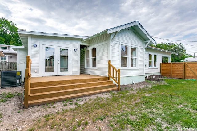 back of house featuring french doors, central AC, a wooden deck, and a lawn