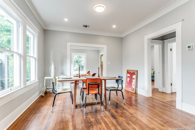 dining space featuring crown molding and hardwood / wood-style flooring