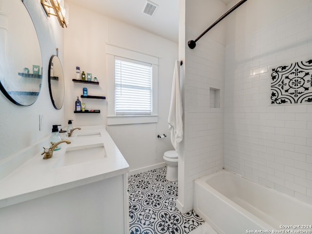 full bathroom featuring toilet, tiled shower / bath combo, vanity, and tile patterned floors