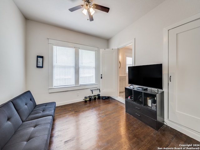 living room featuring ceiling fan and dark hardwood / wood-style flooring