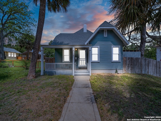 bungalow with a porch and a lawn