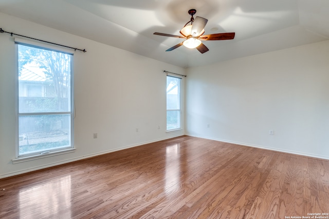 spare room with light wood-type flooring, plenty of natural light, and ceiling fan