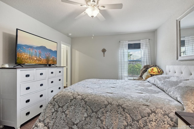 bedroom featuring carpet flooring, a textured ceiling, and ceiling fan