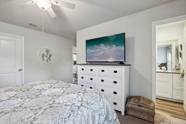 bedroom featuring ensuite bath, light wood-type flooring, and ceiling fan