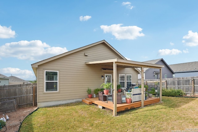 back of property featuring a wooden deck and a lawn