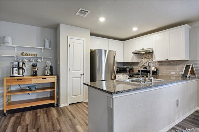 kitchen with sink, kitchen peninsula, stainless steel appliances, white cabinets, and dark hardwood / wood-style floors