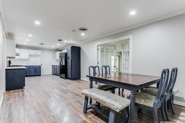 dining space with french doors, crown molding, and light hardwood / wood-style flooring