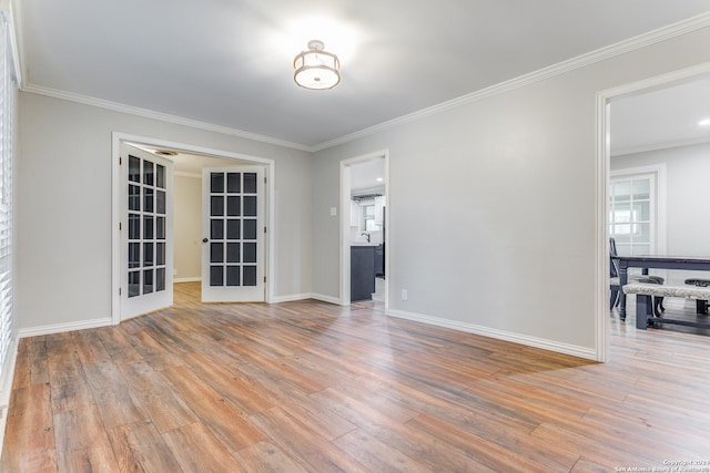 spare room with french doors, ornamental molding, and light wood-type flooring