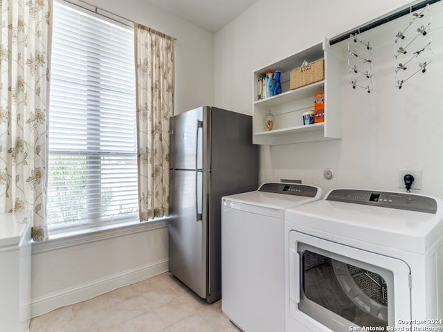 clothes washing area featuring washer and dryer and light tile patterned floors