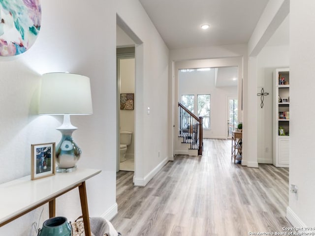 entrance foyer with light wood finished floors, stairs, and baseboards