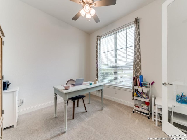 home office featuring a ceiling fan, plenty of natural light, and light colored carpet