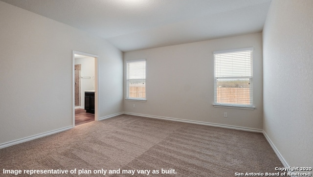 carpeted spare room featuring lofted ceiling