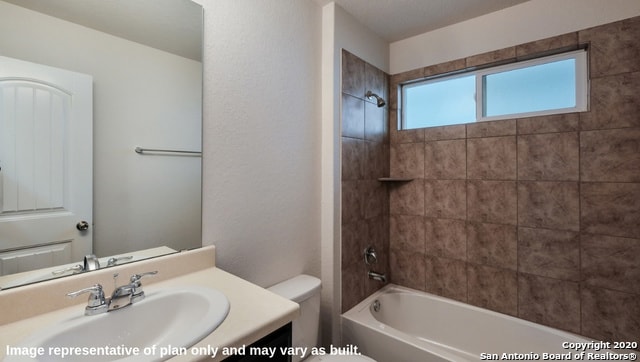 full bathroom with vanity, tiled shower / bath combo, and toilet