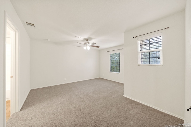 unfurnished room with ceiling fan and carpet