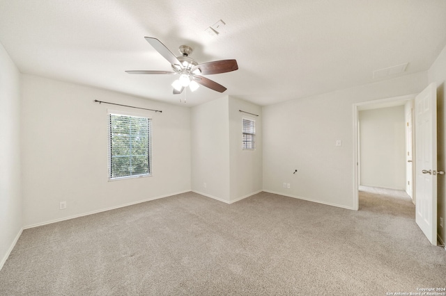 carpeted spare room featuring ceiling fan