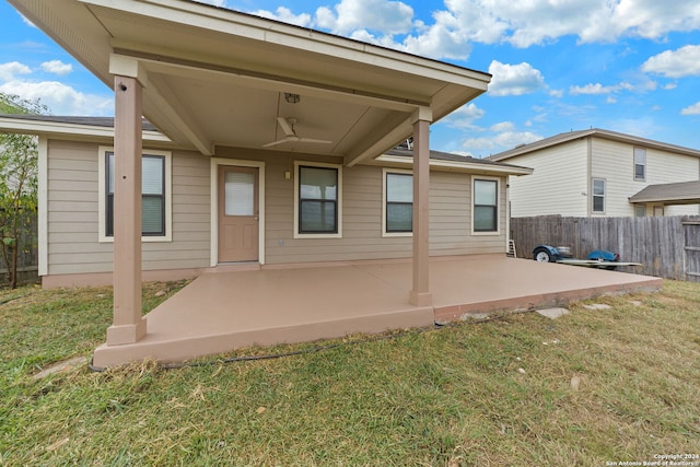 back of property with a patio area, a yard, and ceiling fan