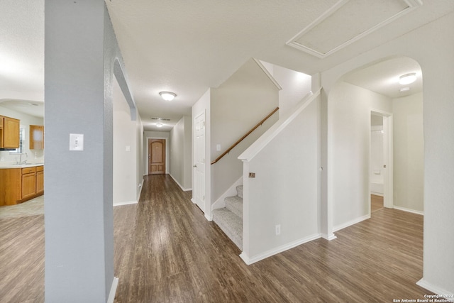 hallway with hardwood / wood-style floors and a textured ceiling