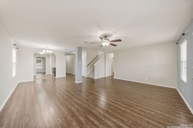 unfurnished living room featuring dark hardwood / wood-style floors and ceiling fan with notable chandelier