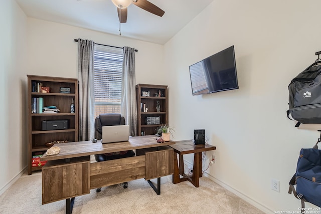 carpeted home office featuring ceiling fan