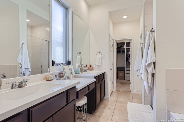 bathroom with a shower with door, vanity, and tile patterned flooring