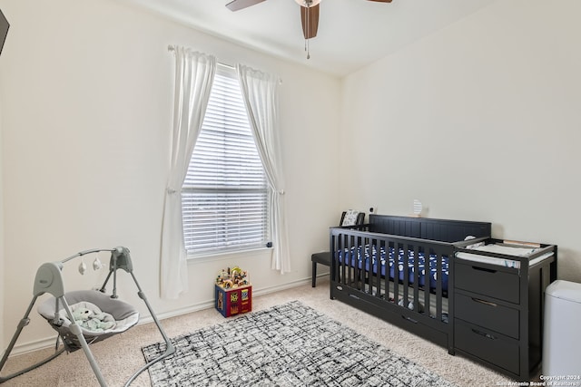 bedroom with ceiling fan and a nursery area