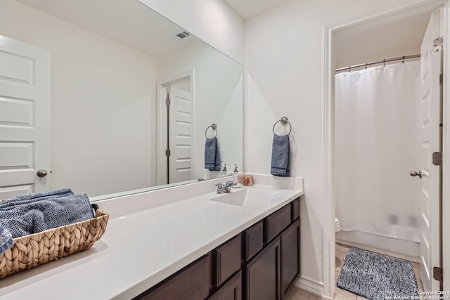 bathroom featuring vanity, toilet, and curtained shower