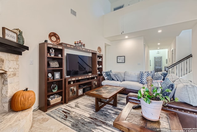 living room with a towering ceiling and a fireplace